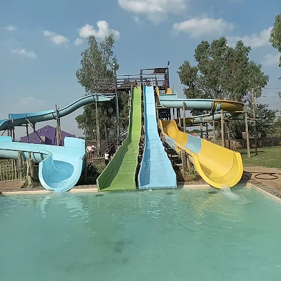 Blue, green and yellow water slides dropping into a rectangular pool