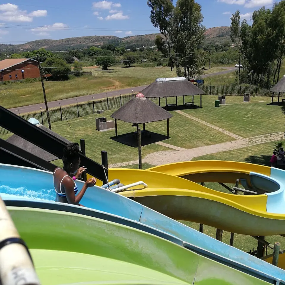 View from the slide tower over thatch picnic shelters and the surrounding hills