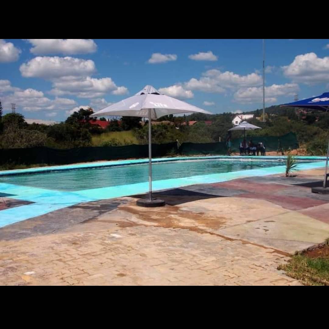 Rectangular pool with a white patio umbrella and pale blue painted surround